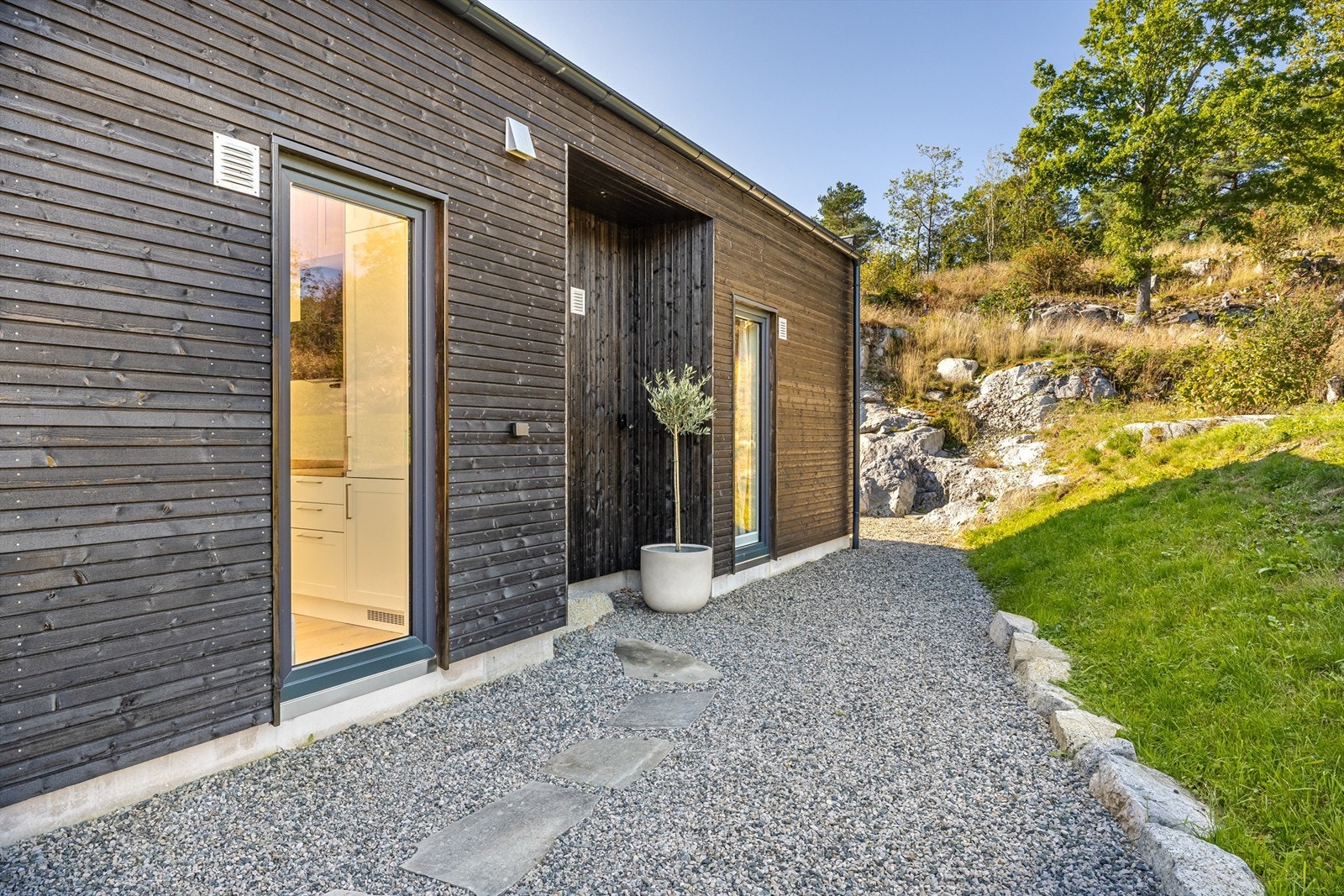 Hytta er omgitt av naturtomt og gruslagte stier. Galleribilde