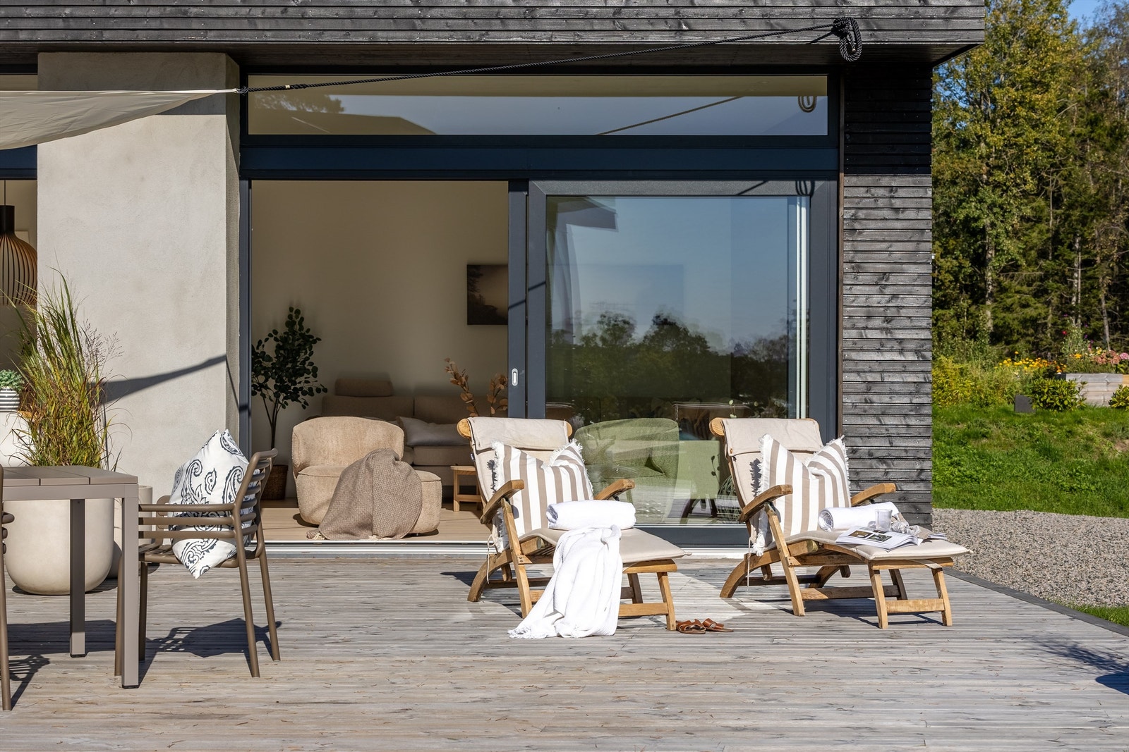 De store skyvedørene skaper en sømløs overgang mellom stue og terrasse. Galleribilde