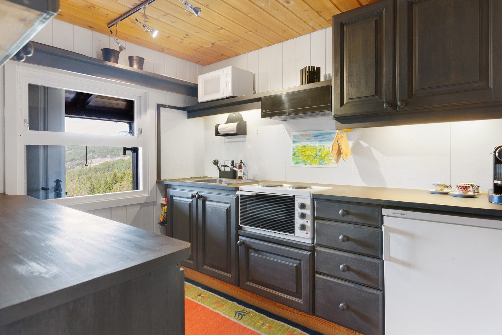 Kjøkkenet har godt med benkeplass, over- og underskap. Galleribilde