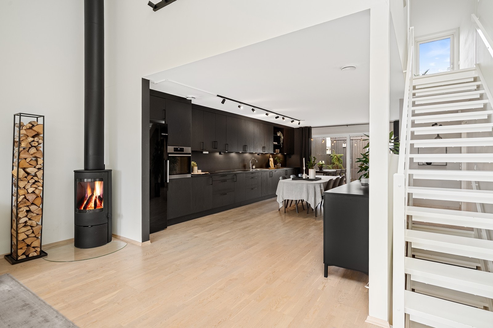 Stilrent sort kjøkken med integrerte hvitevarer som følger handel. Galleribilde