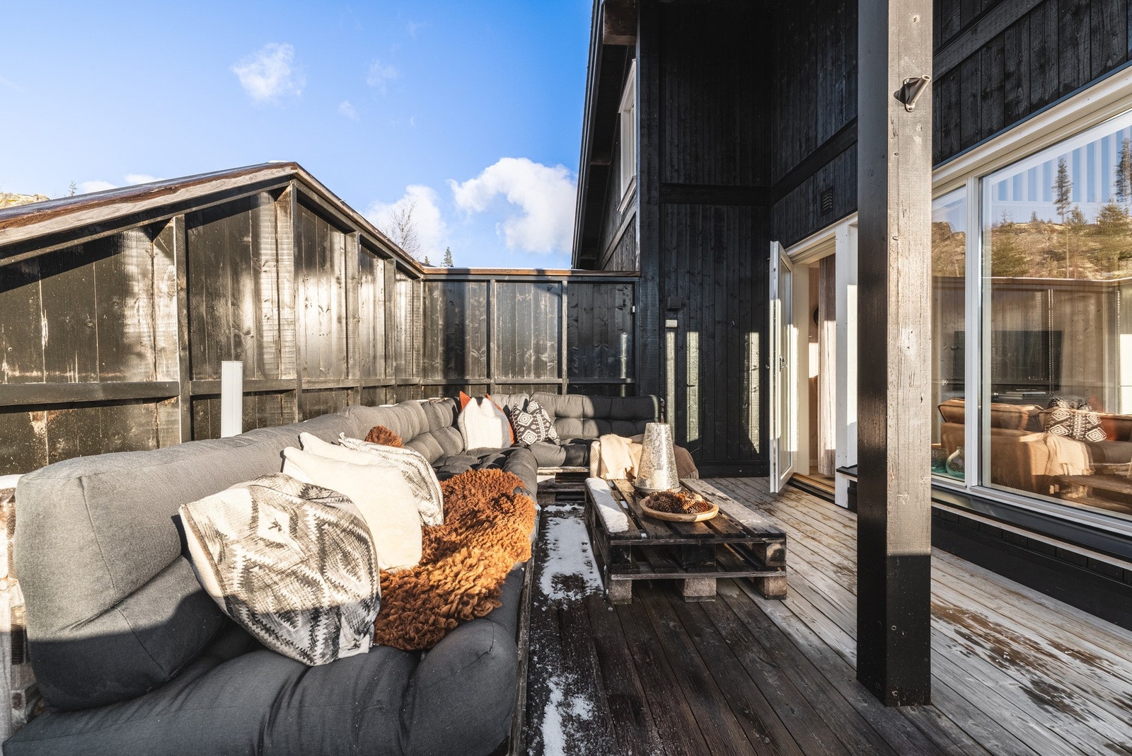 Skjermet uteplass med stilfull trebekledning og komfortabel sittegruppe. Galleribilde