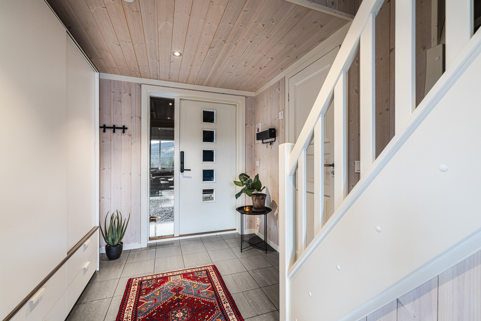 Lys og innbydende flislagt hall med skapplass. Galleribilde