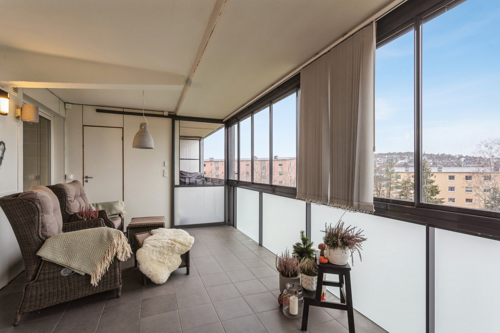 Dette er en helårsvennlig balkong med flislagte gulv og elektriske solgardiner. Galleribilde