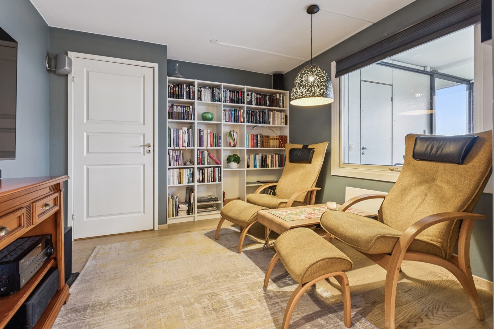 Leilighetens ett av tre soverom er i dag innredet som en lun TV-stue med dobbelfløyet dør. Galleribilde