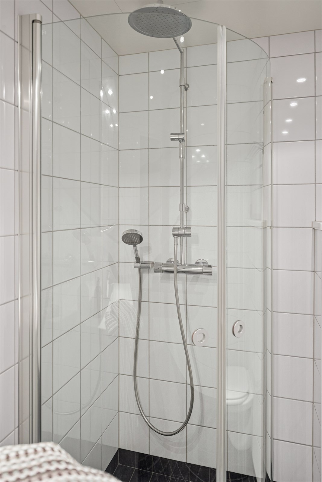 Dusjhjørne med foldbare glassvegger gir fleksibel bruk av dusjområdet. Vegghengt toalett og opplegg for vaskemaskin. Galleribilde