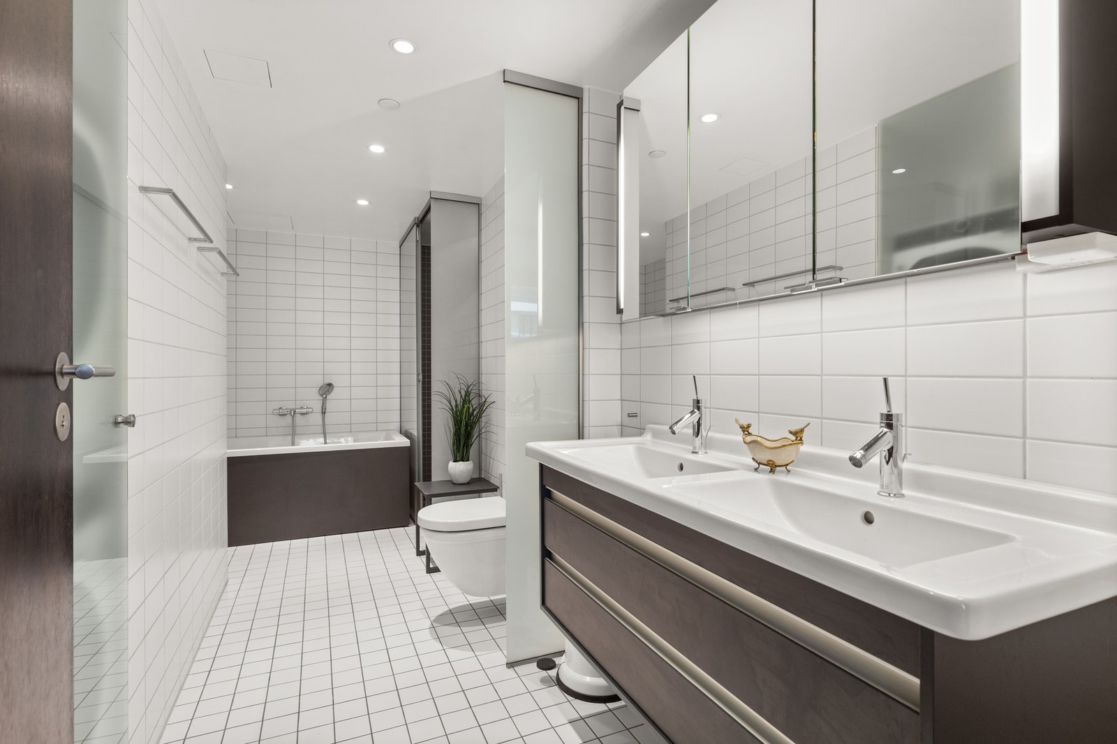 Stilrent en-suite bad med vegghengt klosett, dusjhjørne og servantinnredning. Galleribilde