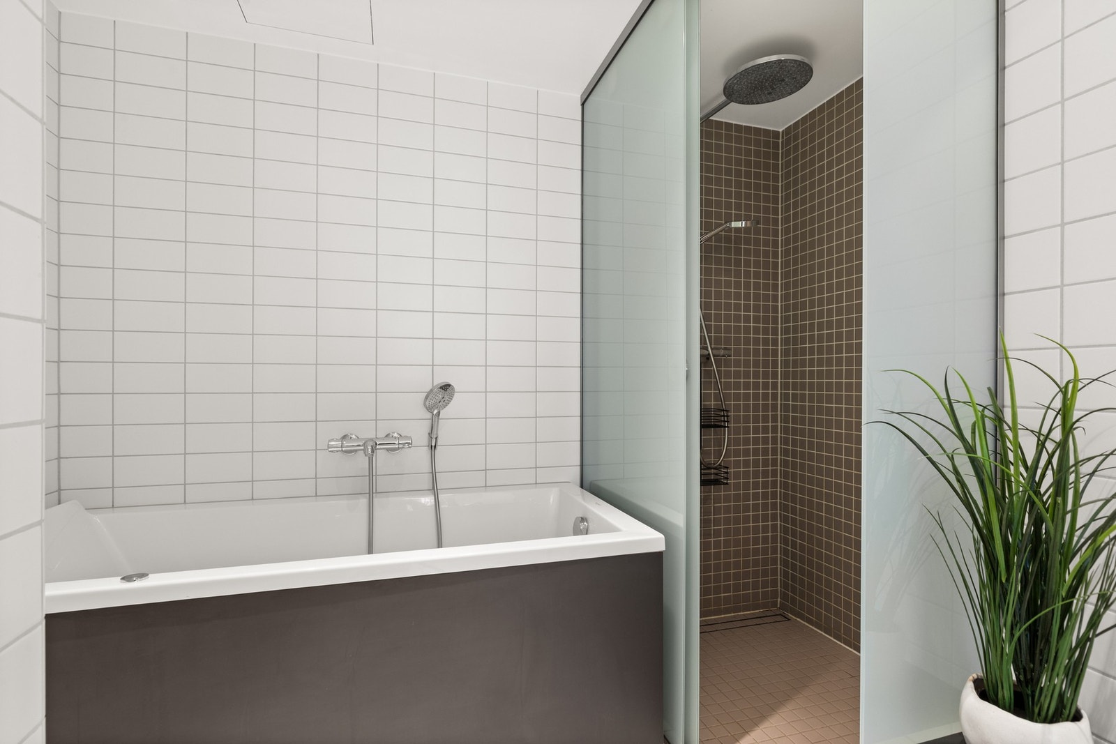 Hovedbadet har en luksuriøs atmosfære, med både badekar og et avskjermet dusjhjørne som gir en spa-lignende opplevelse. Galleribilde