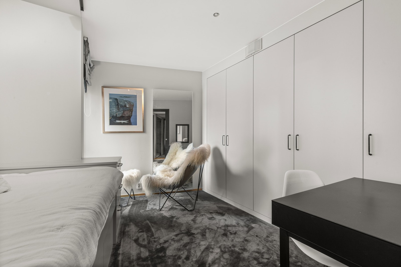 Alle soverommene har egne skapløsninger. Dette soverommet utmerker seg med en romslig og praktisk garderobe som strekker seg langs én vegg, og gir svært god oppbevaringsplass for klær og tilbehør. Galleribilde