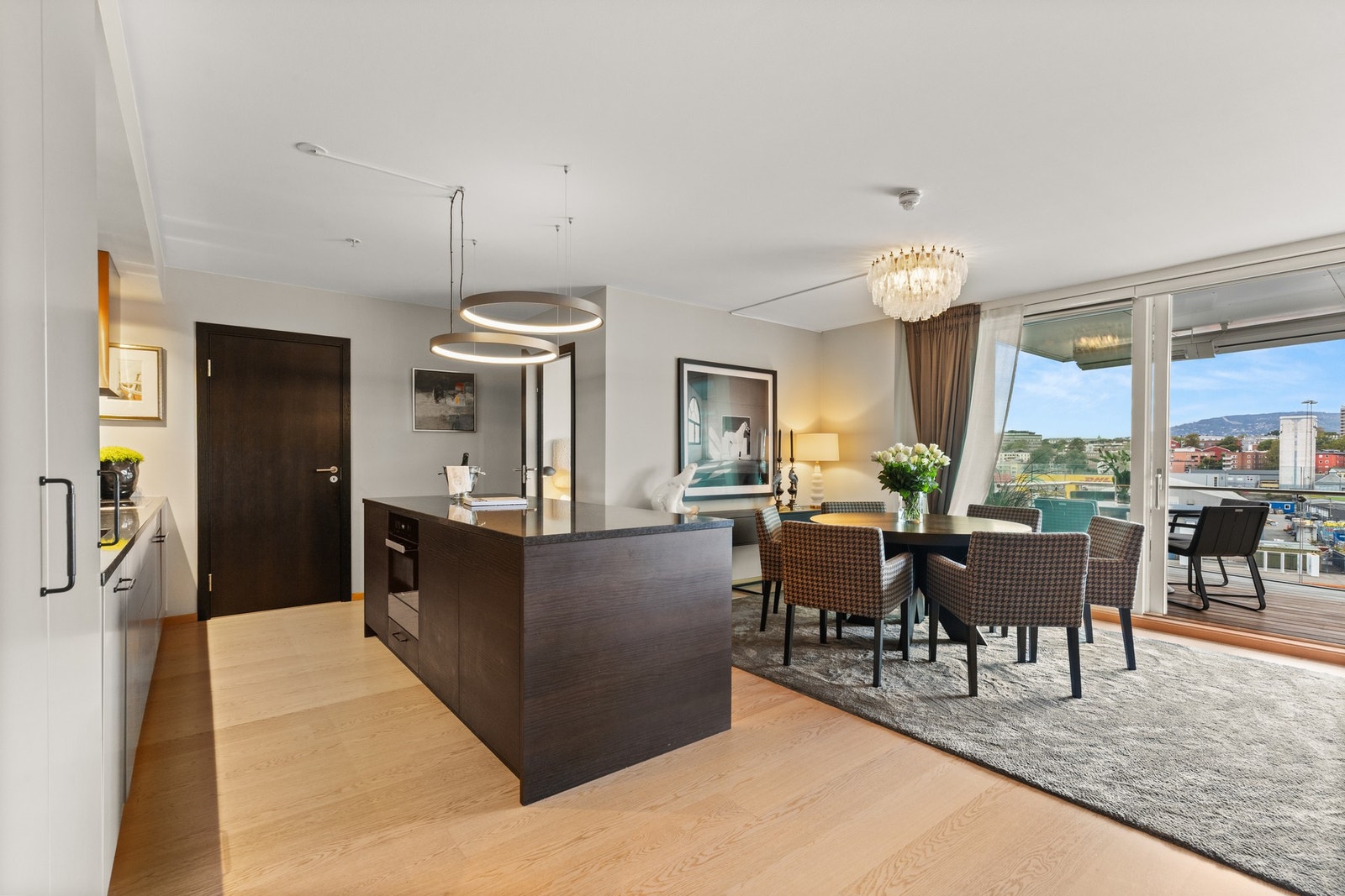 Kjøkkenet har glatte fronter og benkeplate i stein, utstyrt med oppvaskkum og kjøkkenkran. Galleribilde