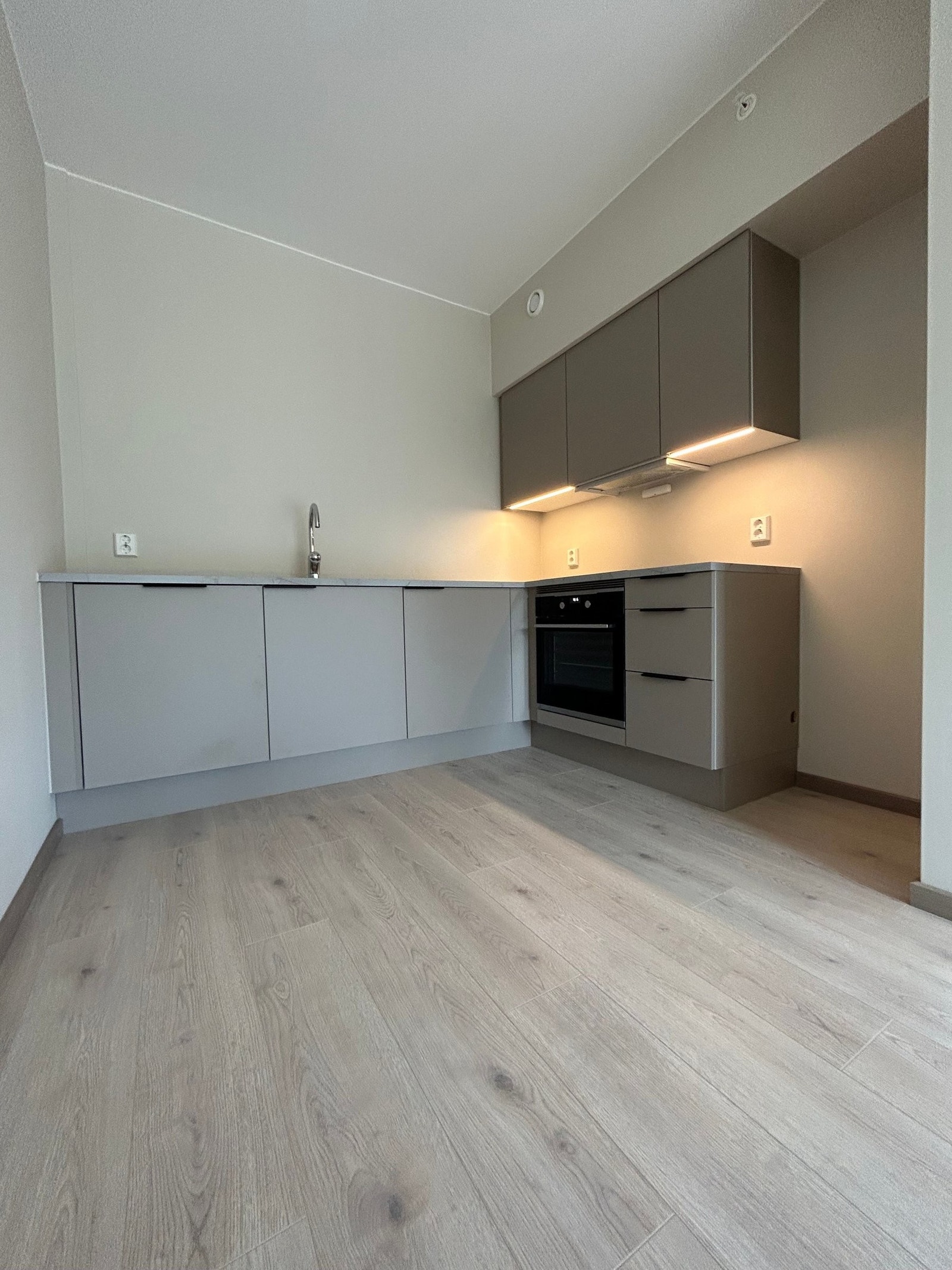 Åpen og sosial løsning mellom stue og kjøkken som utnytter plassen maksimalt Galleribilde