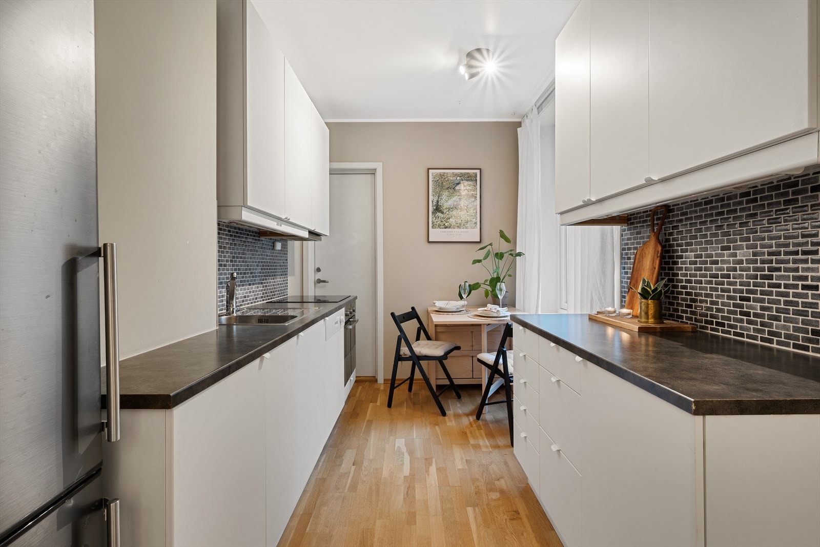 - Tidløs kjøkkeninnredning med slette fronter og benkeplate i laminat - Galleribilde