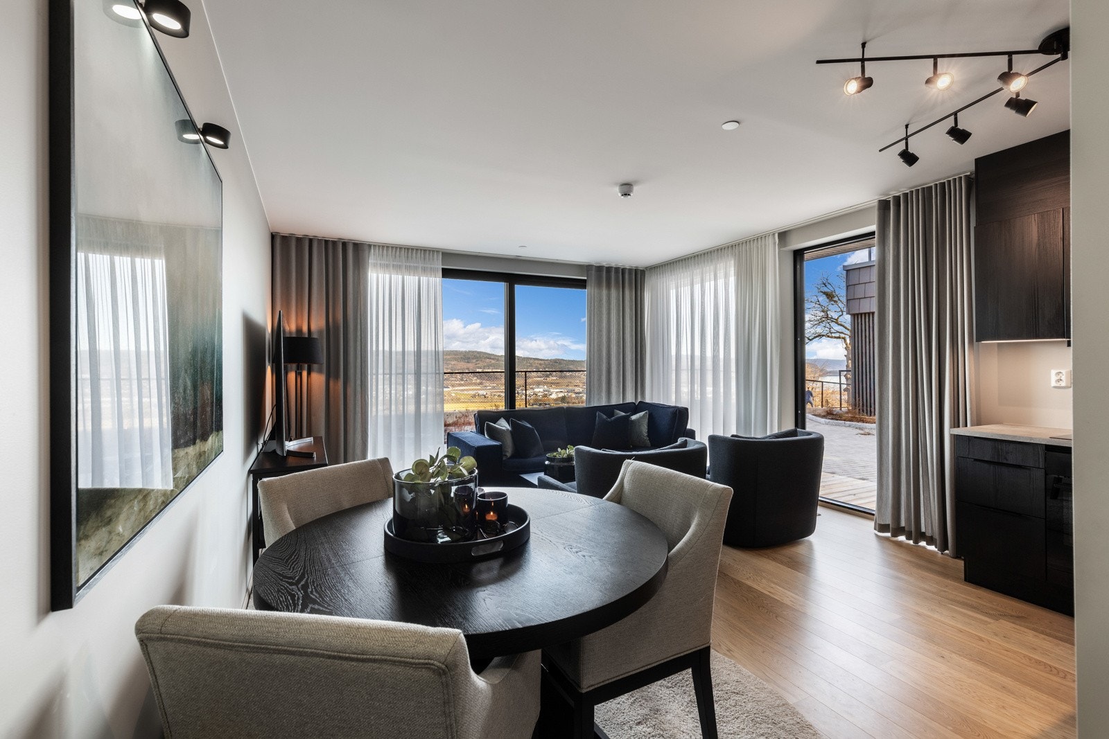 Stue og kjøkken ligger i en åpen løsning med store vindusflater helt ned til gulvet. Galleribilde