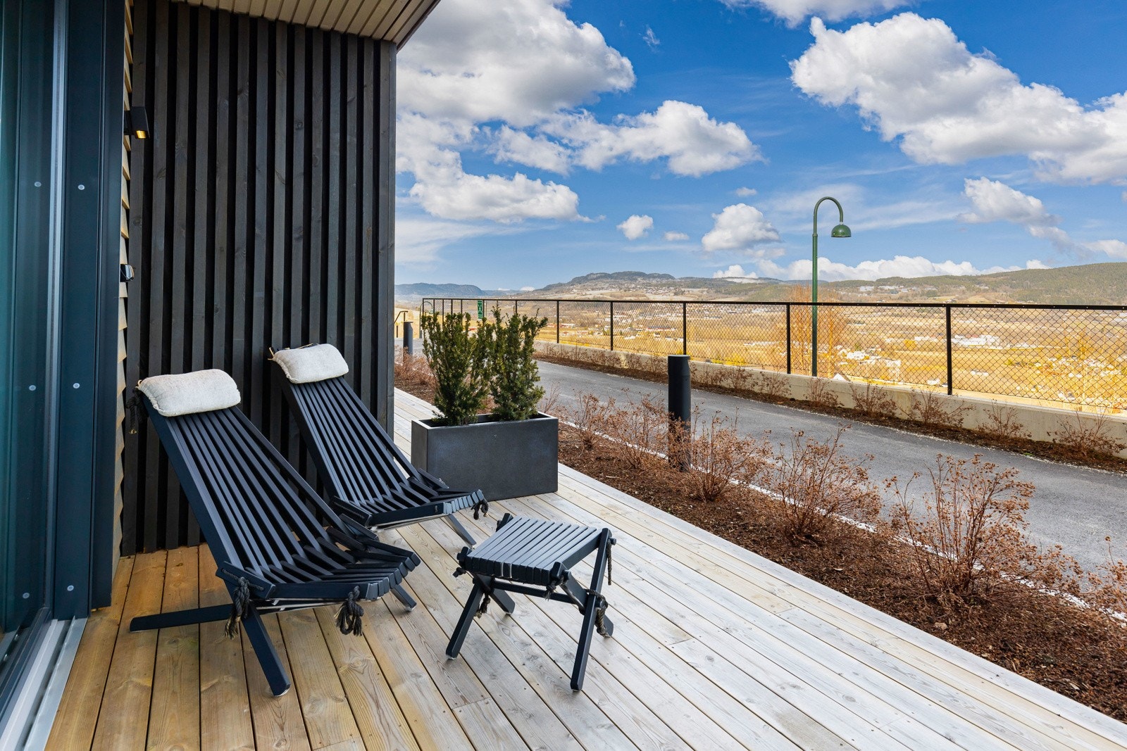 Terrassen rammes inn av blomsterbed og kantstein i skifer, og har levegg med spiler mot naboen. Galleribilde