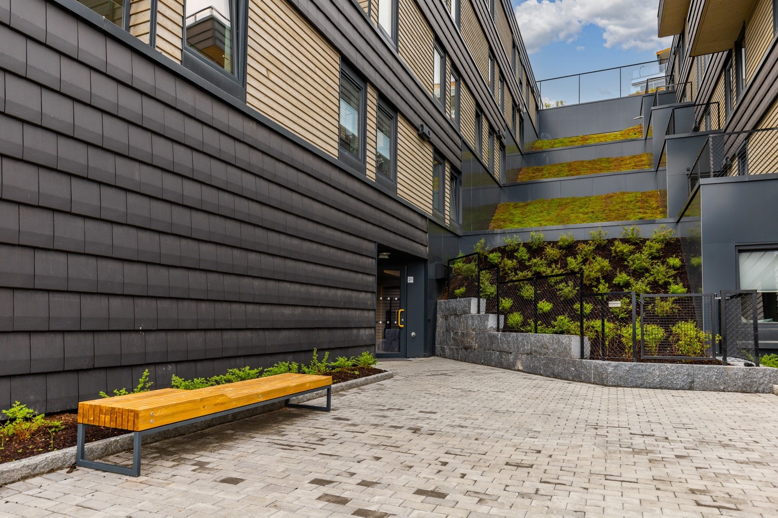 Områdene rundt bygget er pent opparbeidet med belegningsstein, beplantning og belysning for et helhetlig og moderne inntrykk. Galleribilde