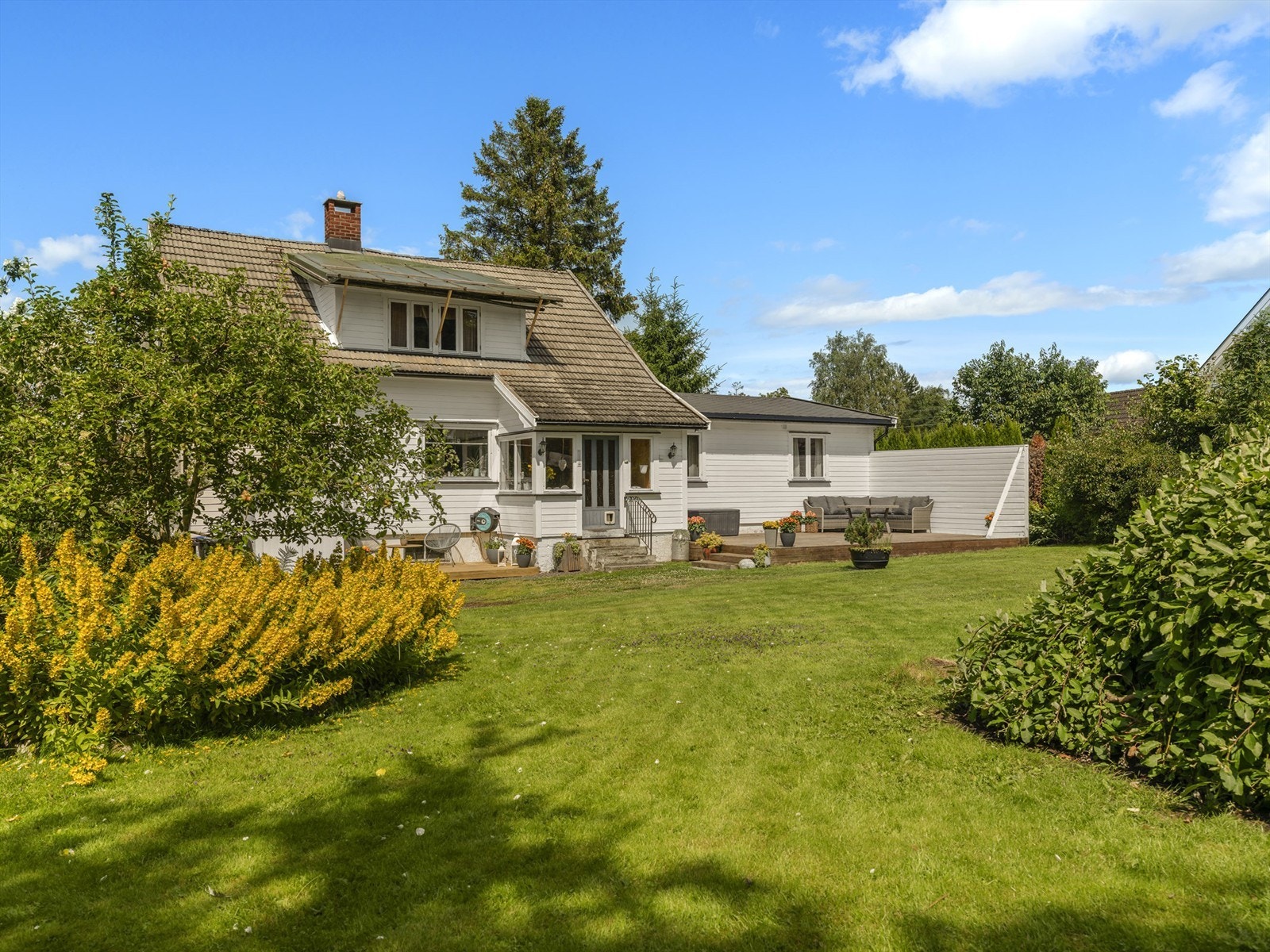 I den meget omfangsrike hagen vokser veletablerte trær og prydbusker som pynter opp rundt boligen. Galleribilde