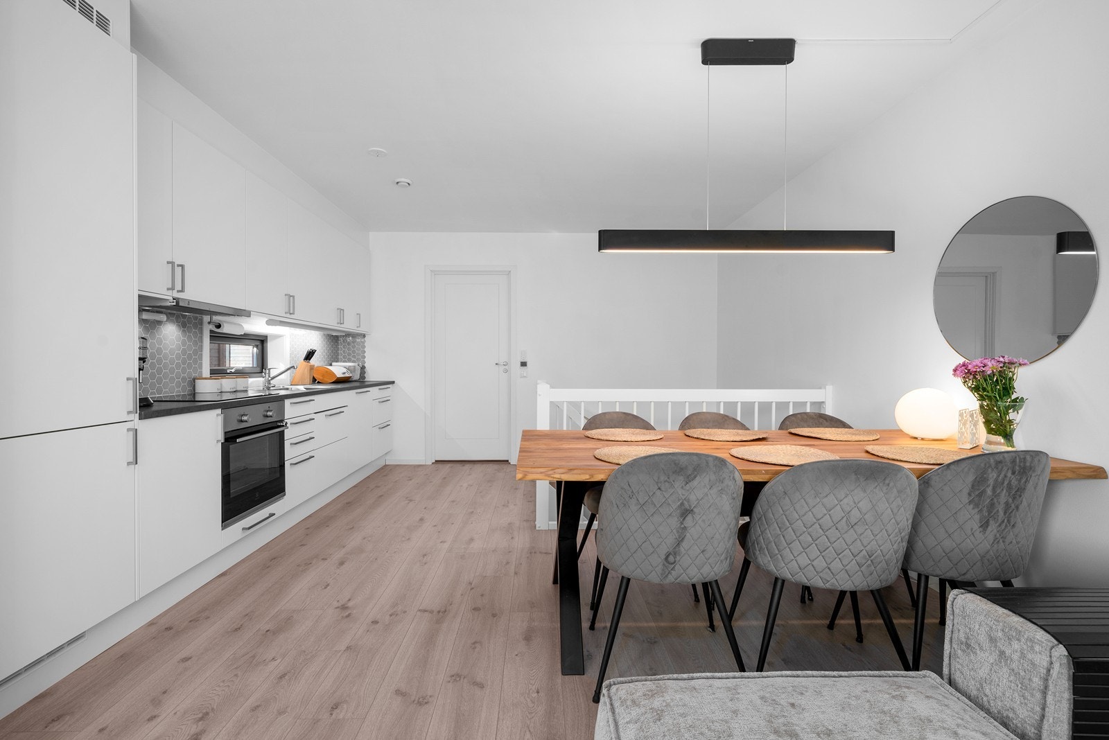 Kjøkkeninnredningen har hvite, slette fronter og laminat benkeplate. Galleribilde