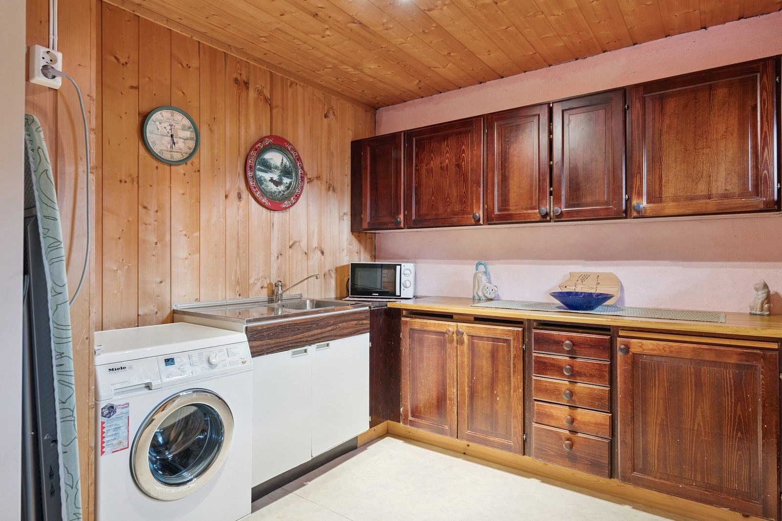 Romslig vaskerom med innredning, utslagsvask og opplegg for vaskemaskin. Galleribilde