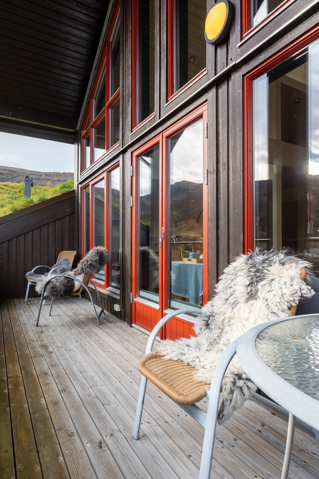 Store vindusflater gir rikelig med naturlig lys til oppholdsrommet. Terrassegulvet er av støpt dekke med tett duk og terrasseplatting (kilde: tilstandsrapport). Galleribilde