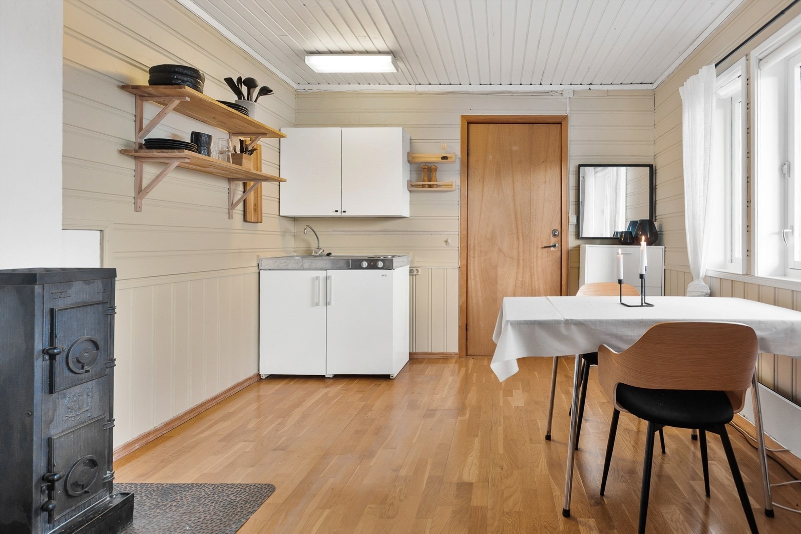 I sokkelen er det innredet til egen leilighet, med et hybelkjøkken, vedovn og en sovealkove Galleribilde