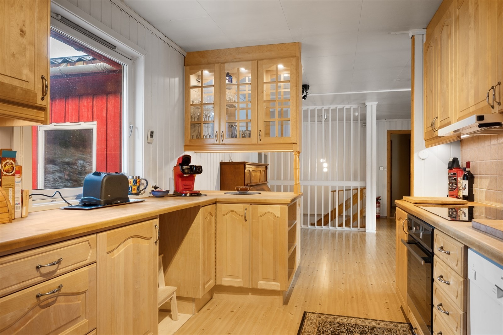 Kjøkkenet har en solid, trehvit innredning. Galleribilde