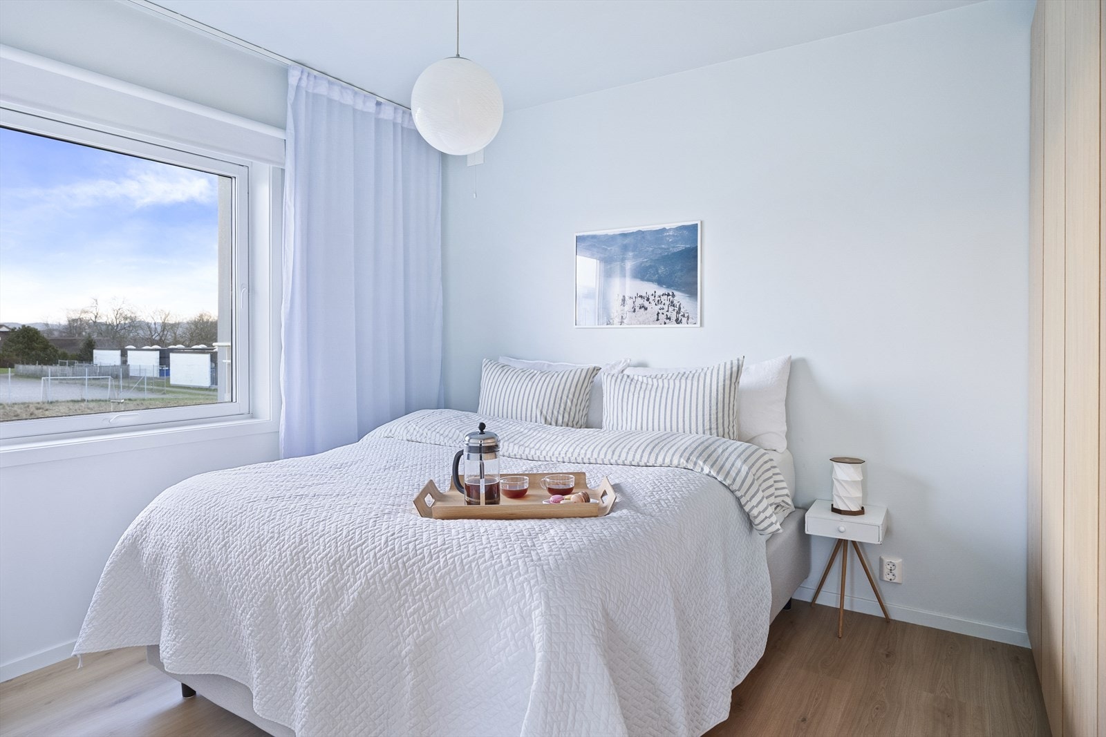 Romslig hovedsoverom i avslappende blåtone og matchende hotellgardiner Galleribilde