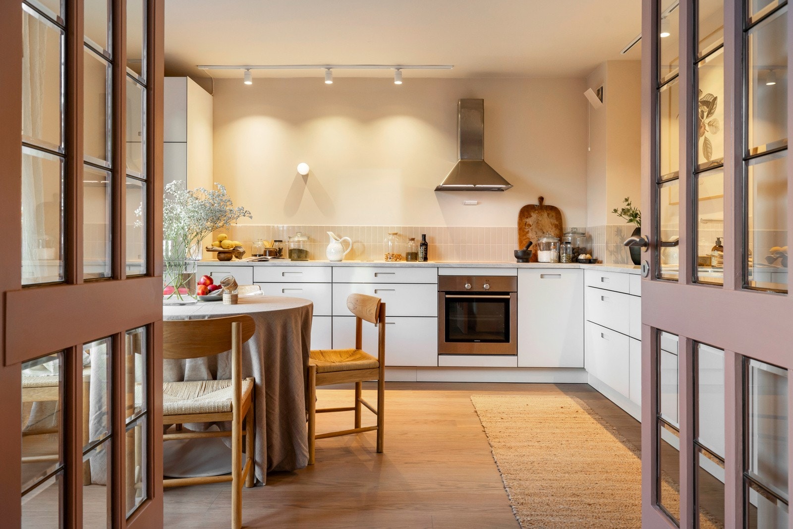 Doble slagdører med glassfelt mellom stue og kjøkken skaper en god flyt og et åpent preg mellom rommene. Galleribilde