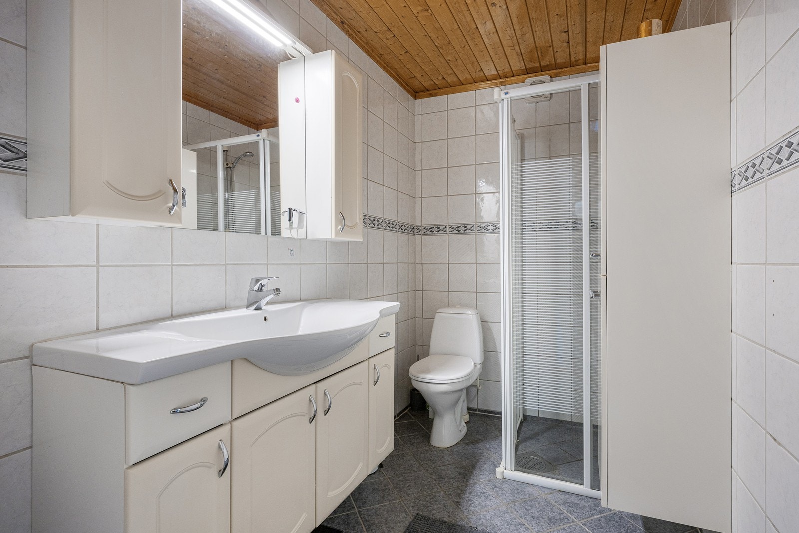 På badet er det toalett, varmekabler og et dusjhjørne med skyvedører av glass. Galleribilde