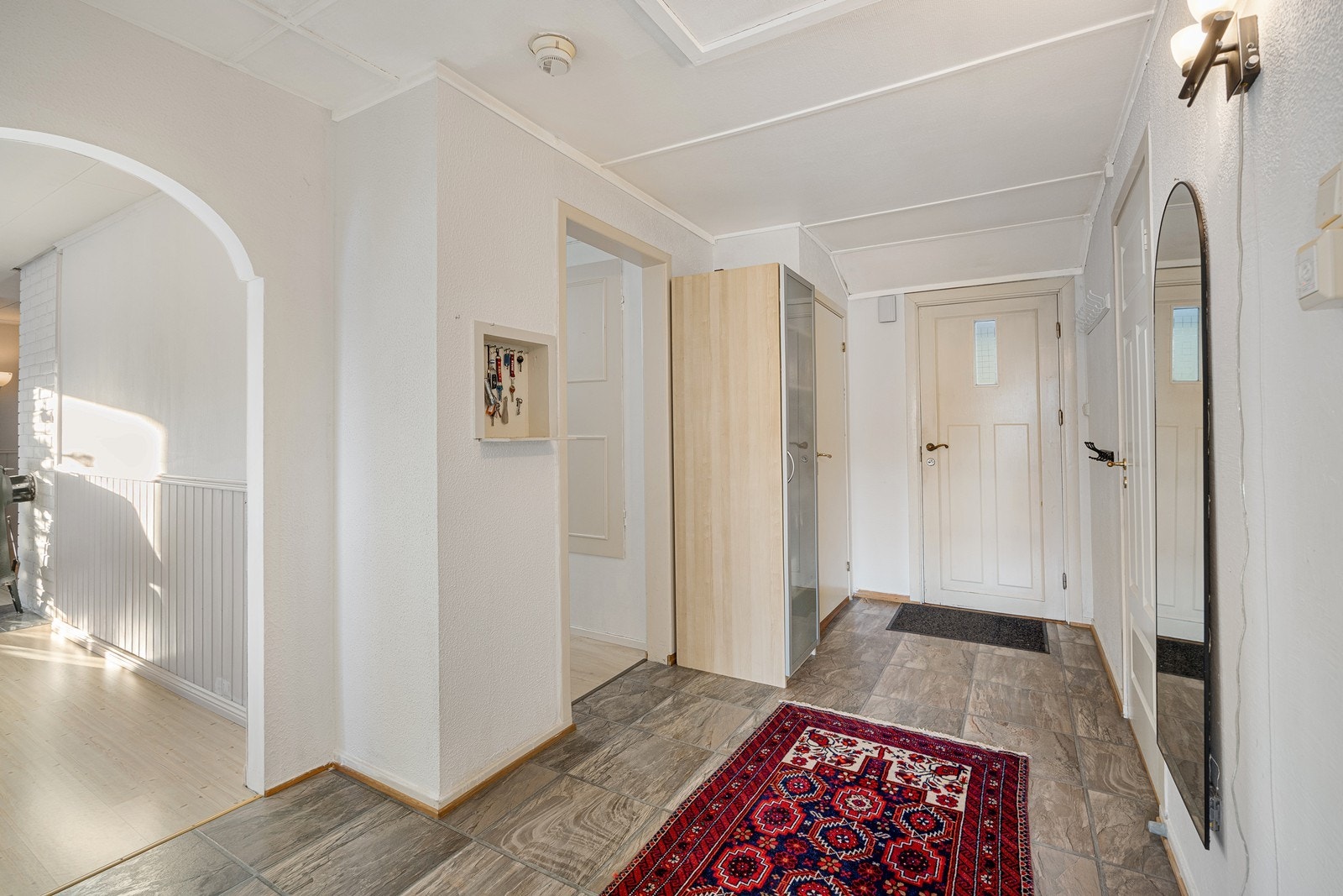 Entreen innredet med flismønstert vinylbelegg på gulvet. Galleribilde