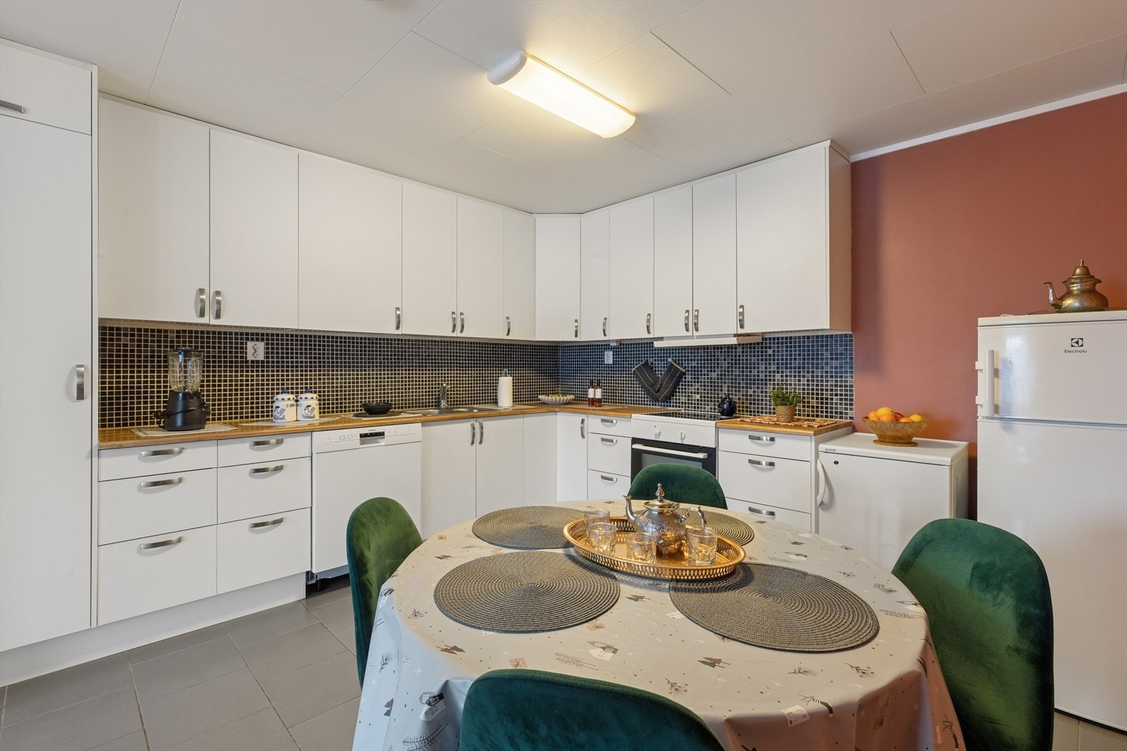 Lys innredning med glatte fronter og benkeplate i heltre, samt plass i innredningen til hvitevarer. Galleribilde