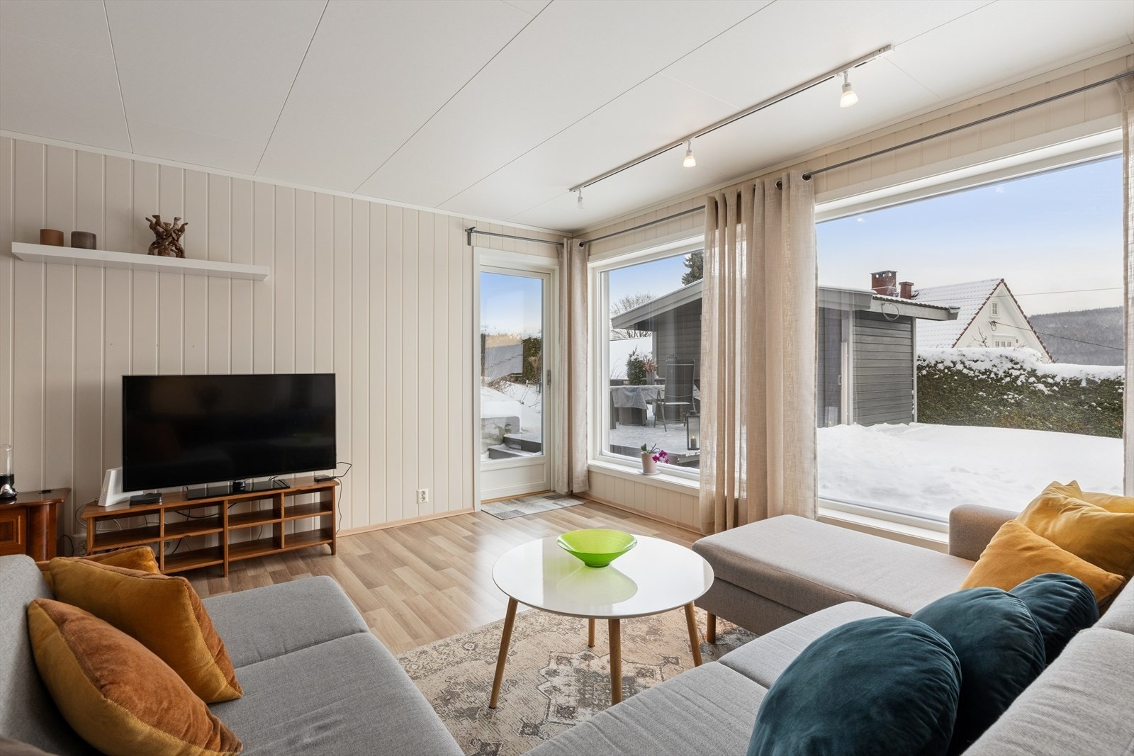 Stue med store vindusflater, utgang til uteområde og plass til en hyggelig sofa sone. Galleribilde