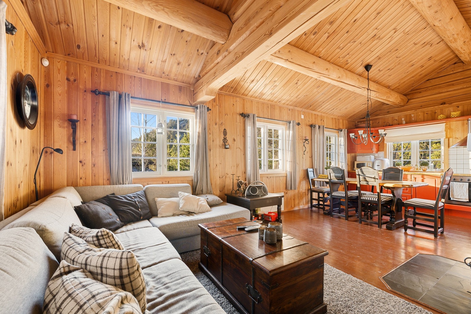 Innbydende stue med god takhøyde og synlige takbjelker som gir et solid og gjennomført hyttepreg. Galleribilde