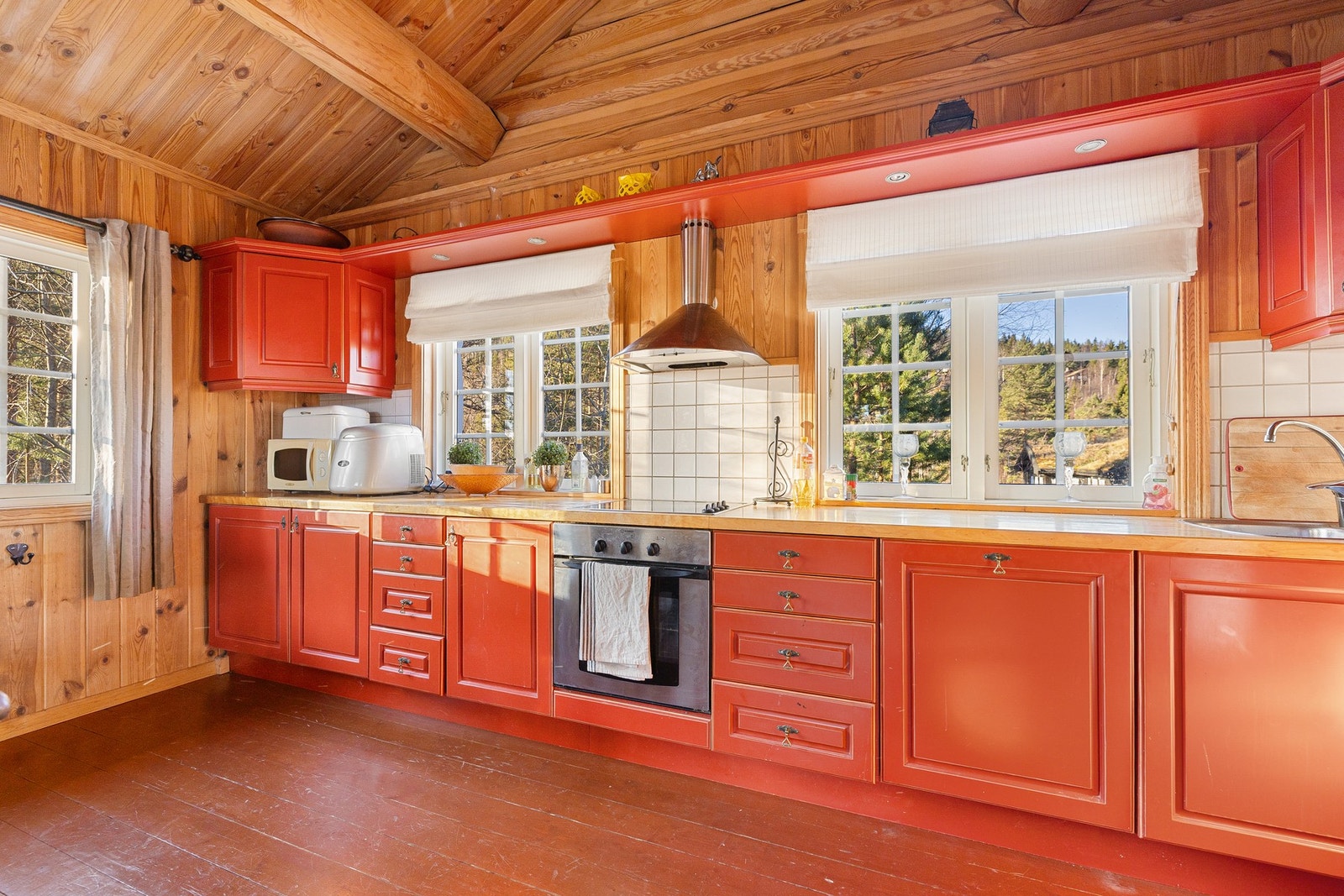 Kjøkkenet har naturlig lysinnslipp fra vinduer og en praktisk løsning som fungerer godt både til hverdagsbruk og sosial matlaging. Galleribilde