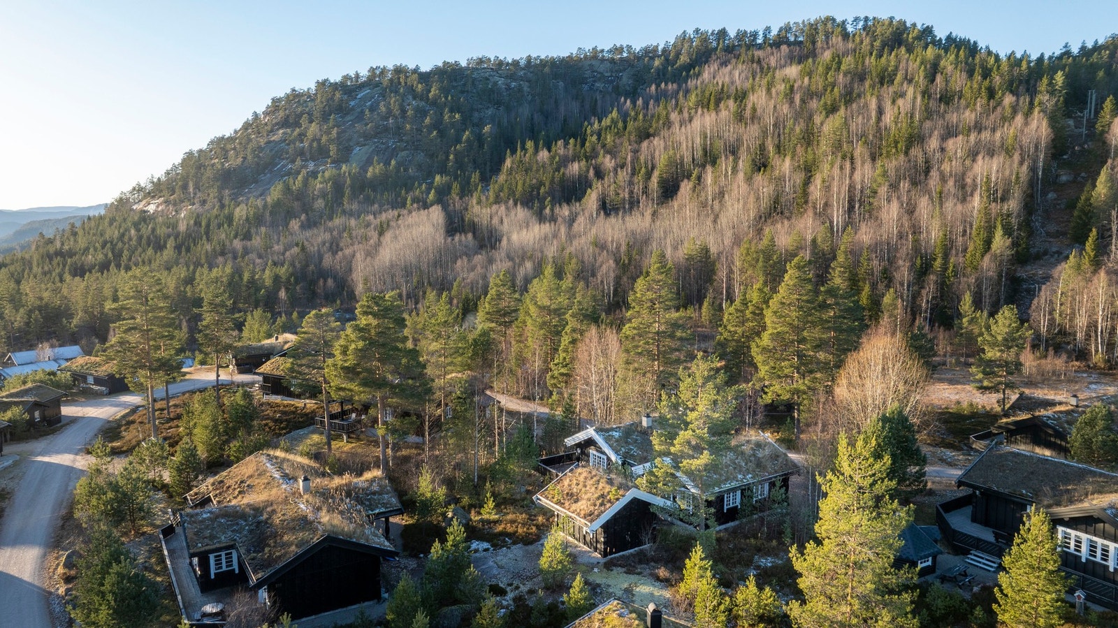 Oversiktsbilde av hyttefeltet omgitt av skog og fjell. Galleribilde