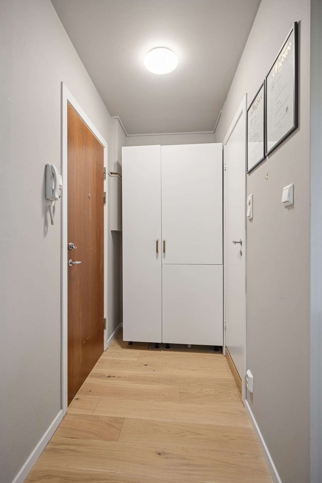 Innbydende gang hvor selger har optimalisert plassen ved å integrere kjøleskapet i skap, slik at stuearealet utnyttes best mulig. Galleribilde