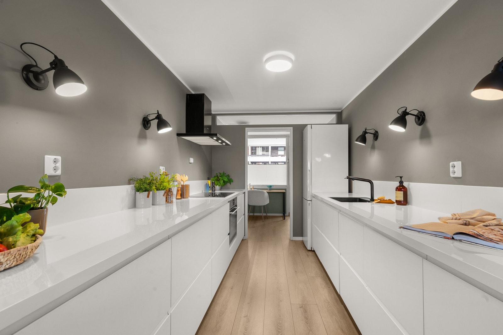 Kjøkkenet er stilrent, moderne og innbydende. Her får du en lys innredning fra 2017 med laminerte benkeplater, plateslått backsplash av kvarts og slette fronter som gir et tidløst og elegant preg. Galleribilde