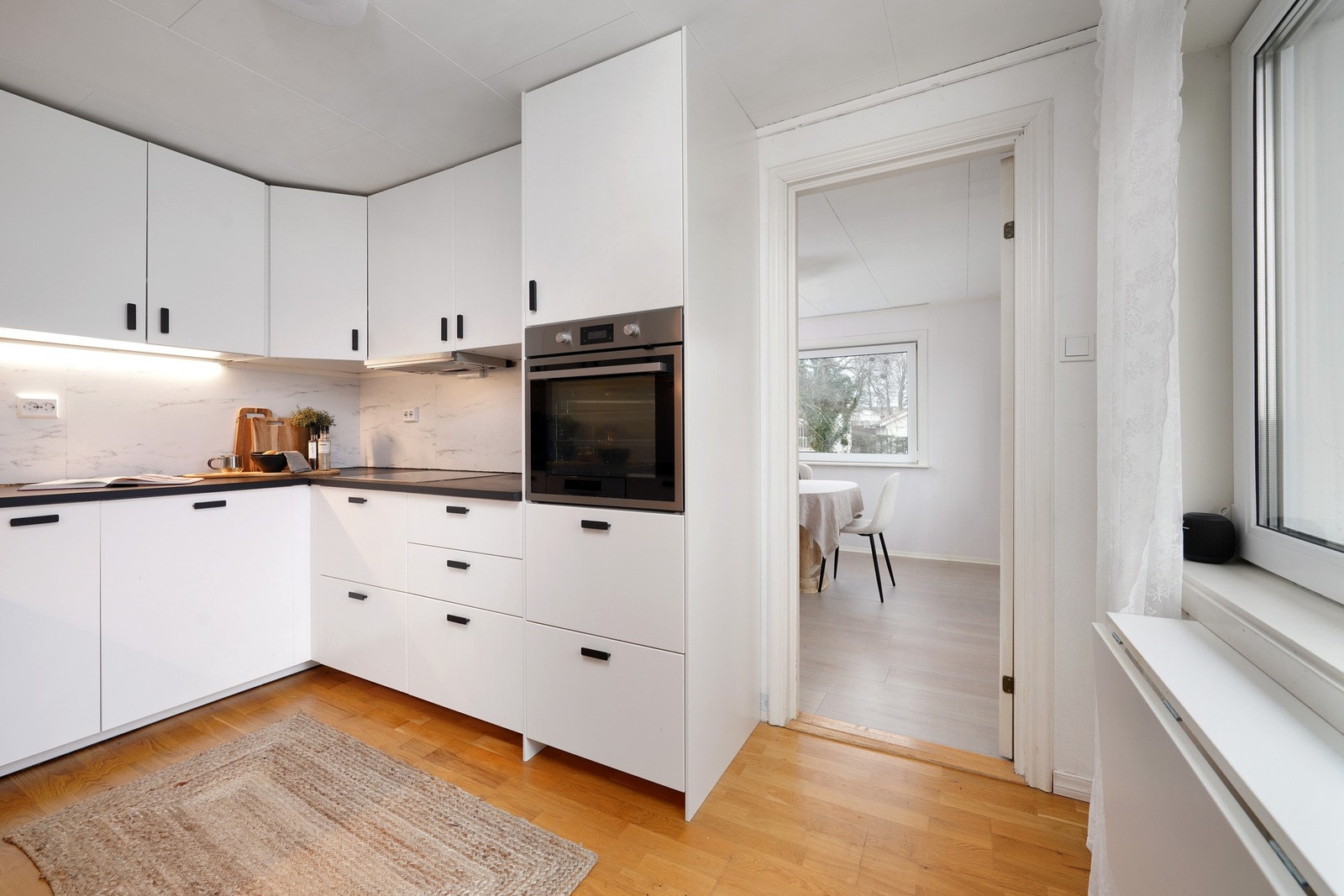 Hvite overflater og integrerte hvitevarer på kjøkkenet. Galleribilde