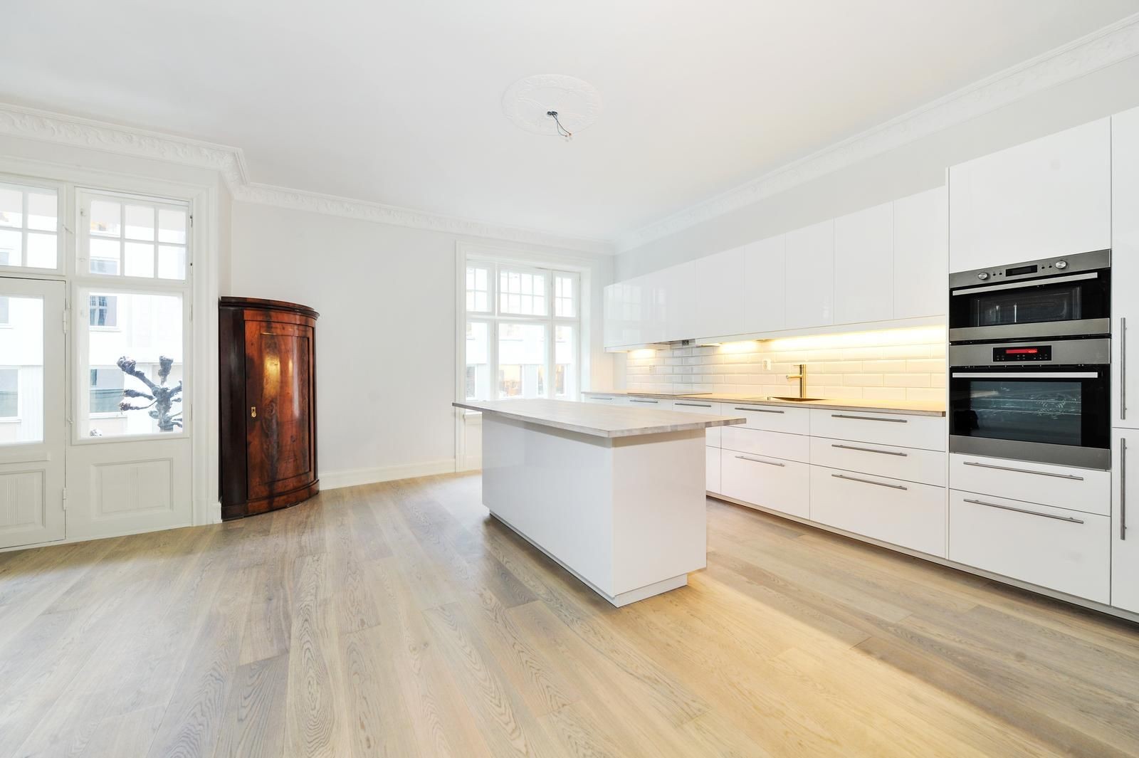 Lyst og pent kjøkken med integrerte hvitevarer. Galleribilde