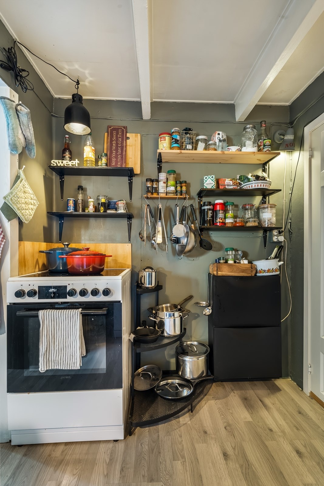 Kjøkkenet har mye hyller for oppbevaring. Galleribilde