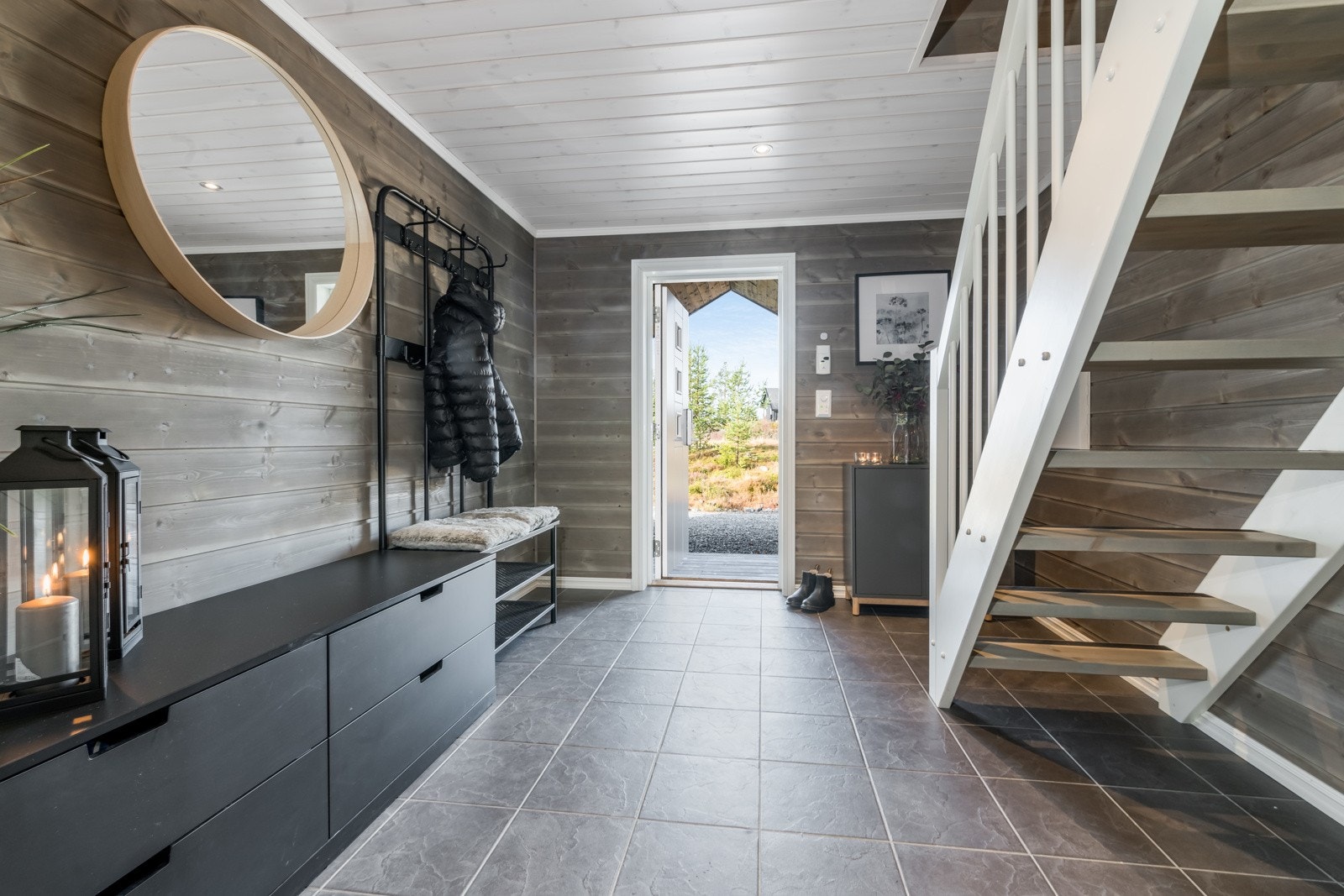 Velkommen inn! Romslig entré med fliser og gulvvarme. Plass til garderobeløsning og oppbevaring under trapp. Galleribilde