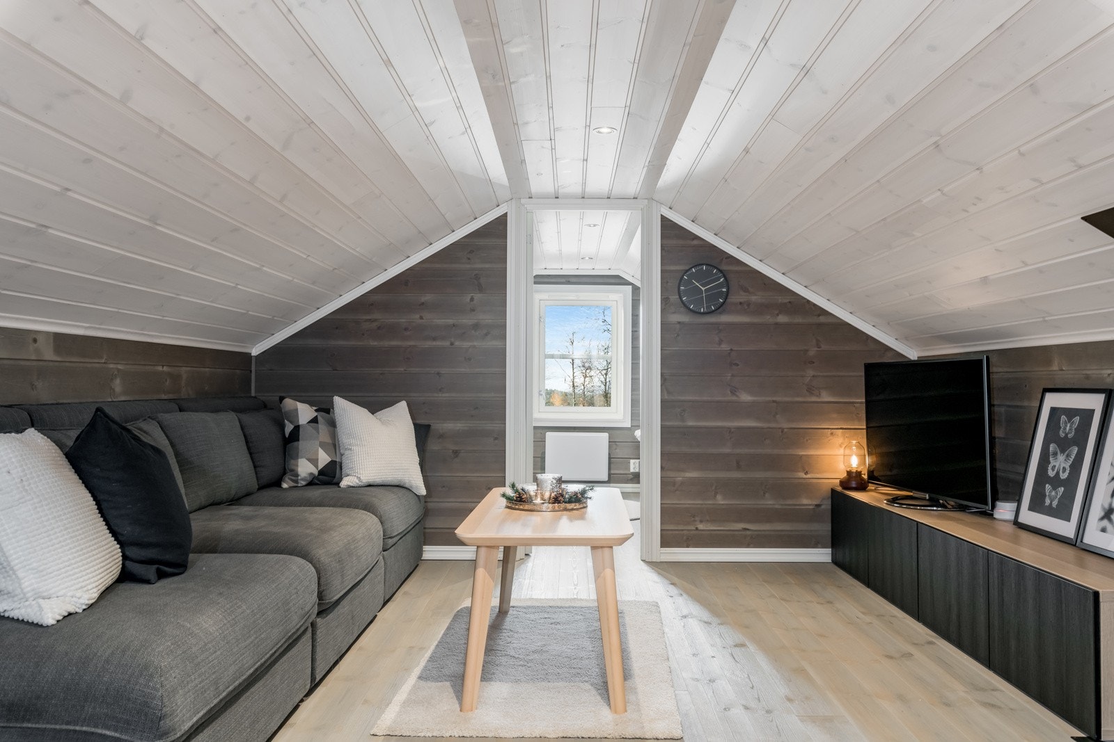 Innredet loftstue med tv-krok og arbeidsbord for pc og spill. Galleribilde