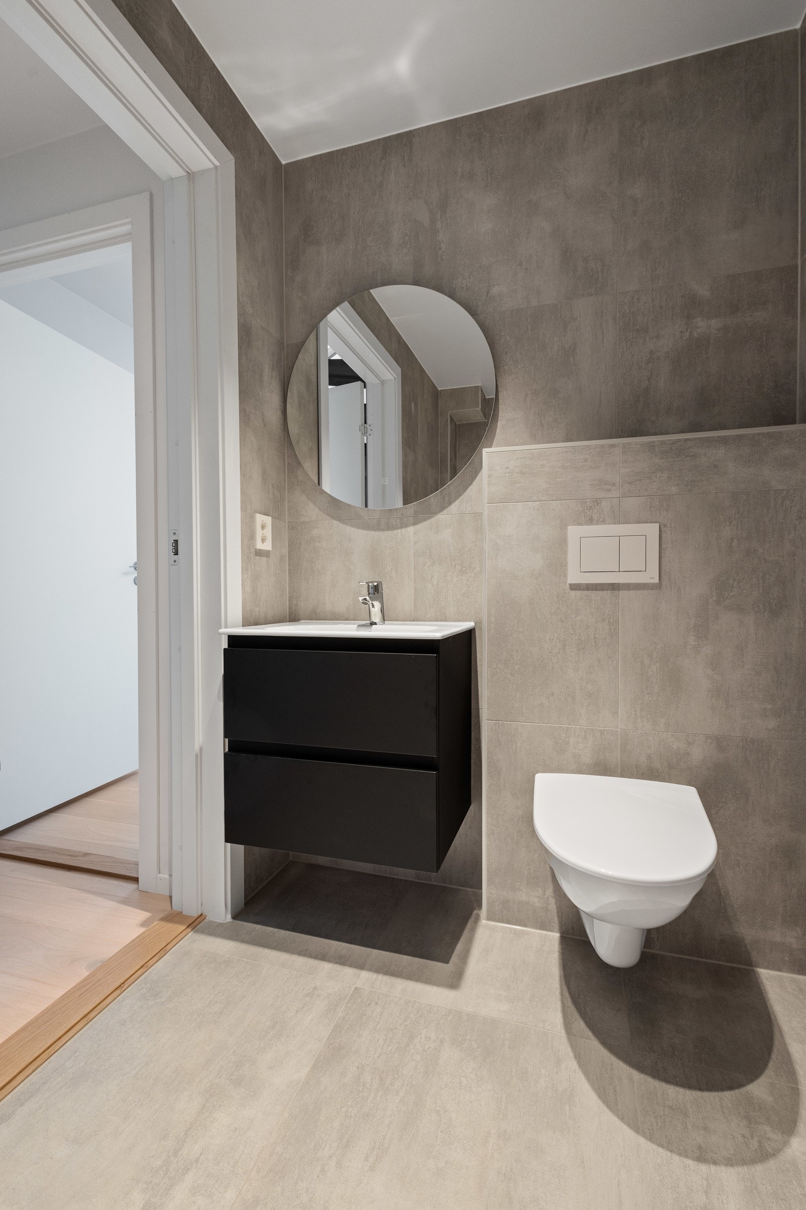 Delikat, flislagt baderom innredet med dusj, servant med skuffeseksjon og klosett. Galleribilde