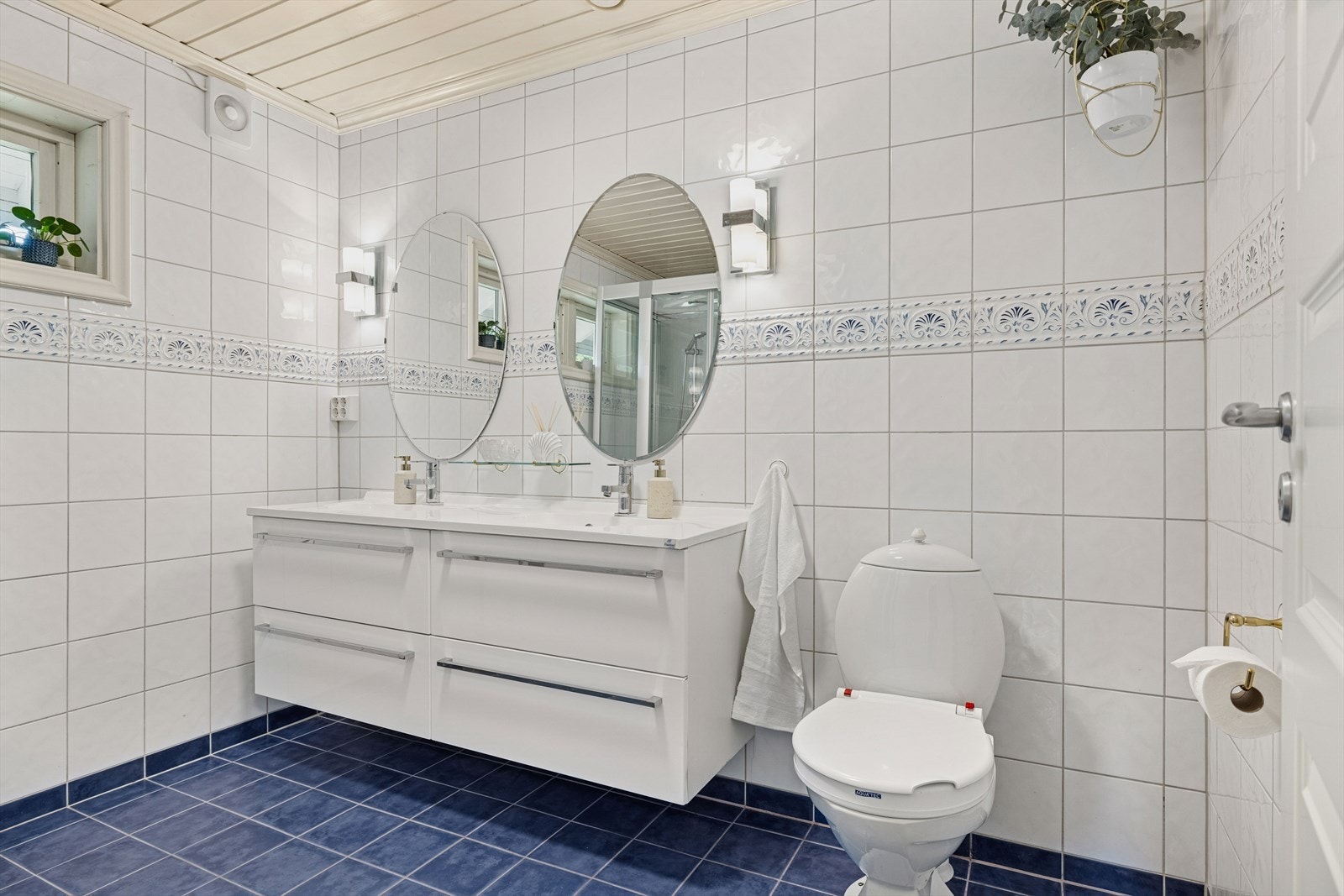 Romslig og moderne baderomsinnredning med mye oppbevaringsplass. Gulvstående toalett. Galleribilde