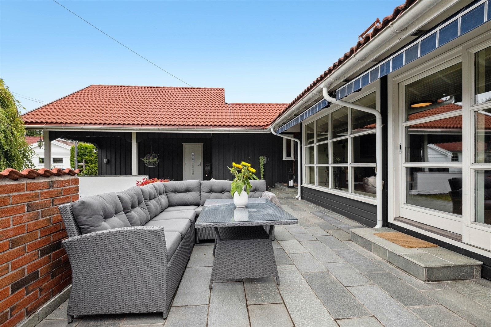 Fra stuen er det videre utgang til en herlig terrasse i front. Selger opplyser om sol fra morgen til kveld på eiendommen. Galleribilde