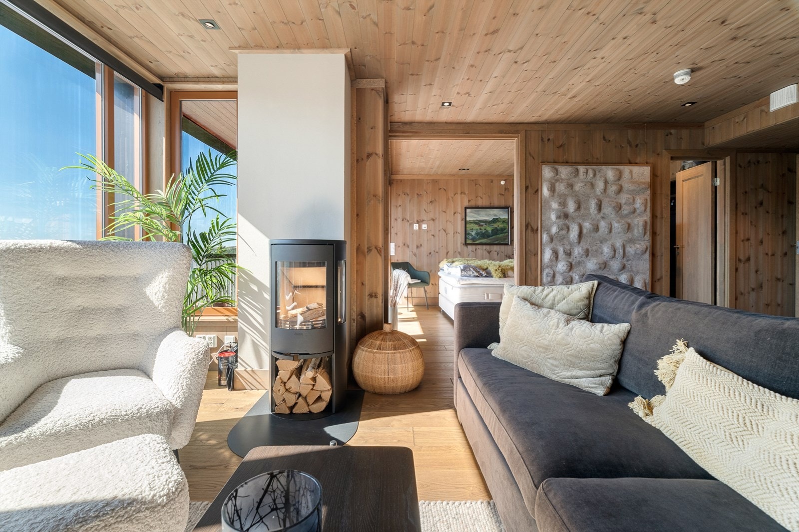 Lys og luftig stue med store vindusflater, trepanel og gjennomført fjellestetikk Galleribilde