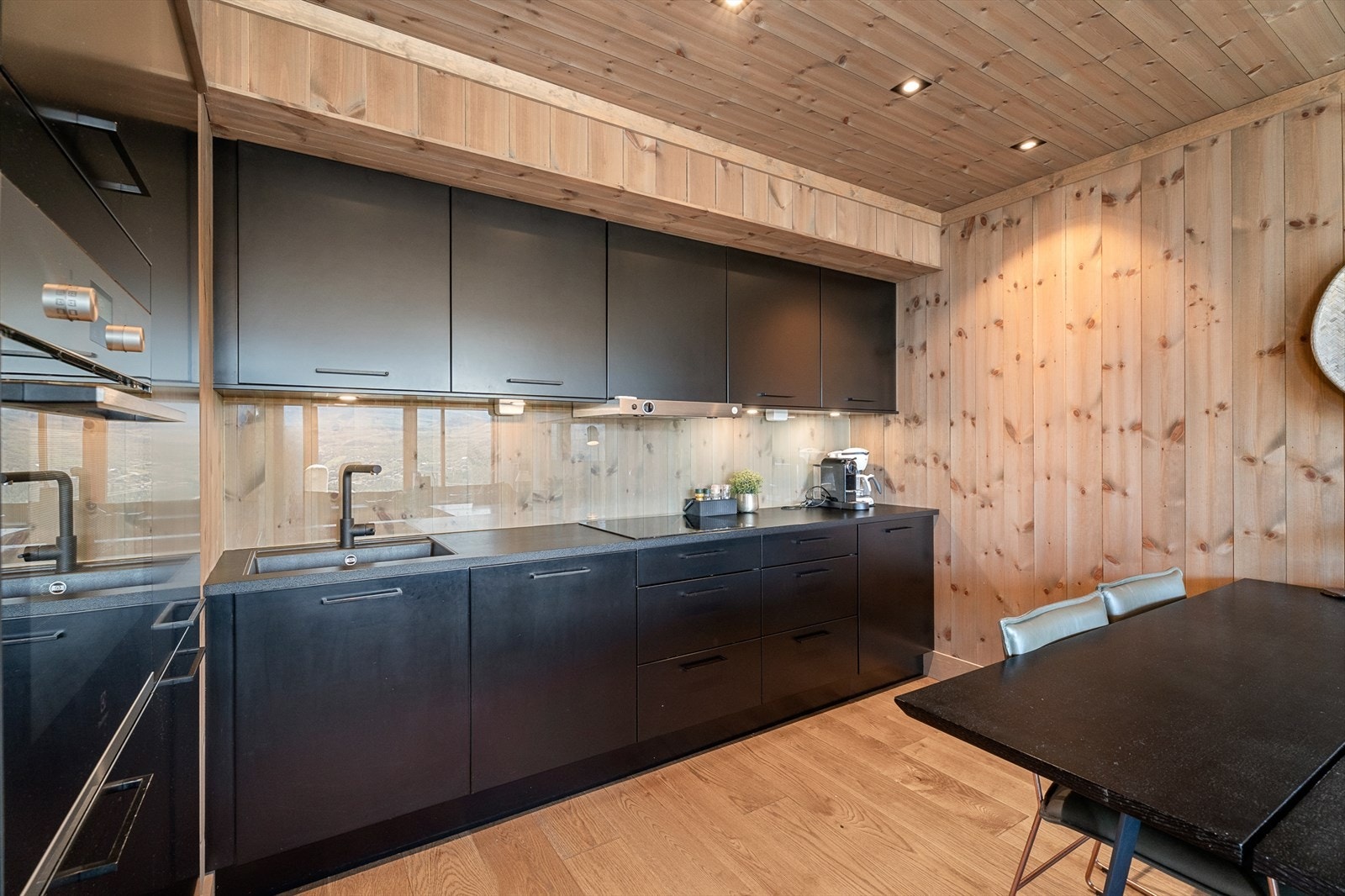 Stilrent kjøkken med sorte detaljer og integrerte hvitevarer Galleribilde