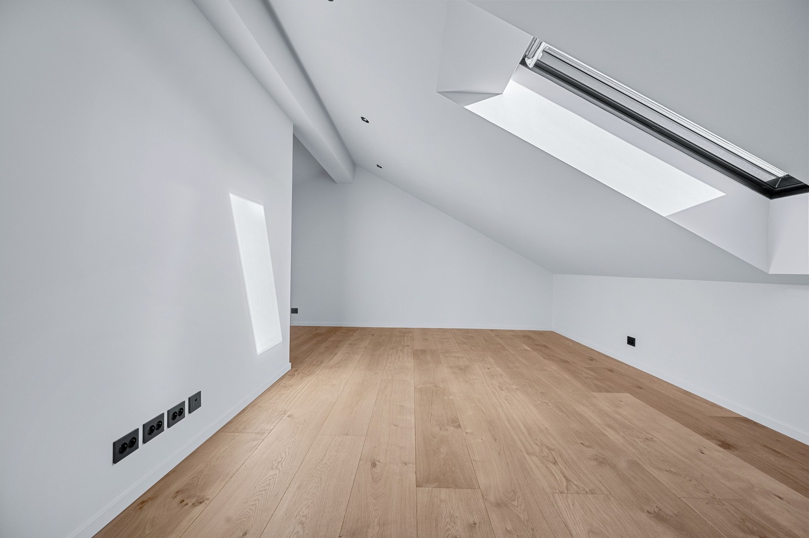 Loftstuen har gode lysforhold med takvindu og god plass for TV og sofa Galleribilde