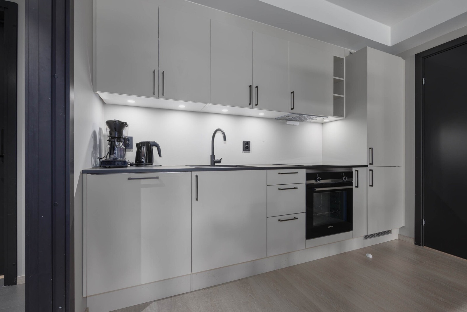 Åpen kjøkkenløsning med integrerte hvitevarer av god kvalitet. Galleribilde