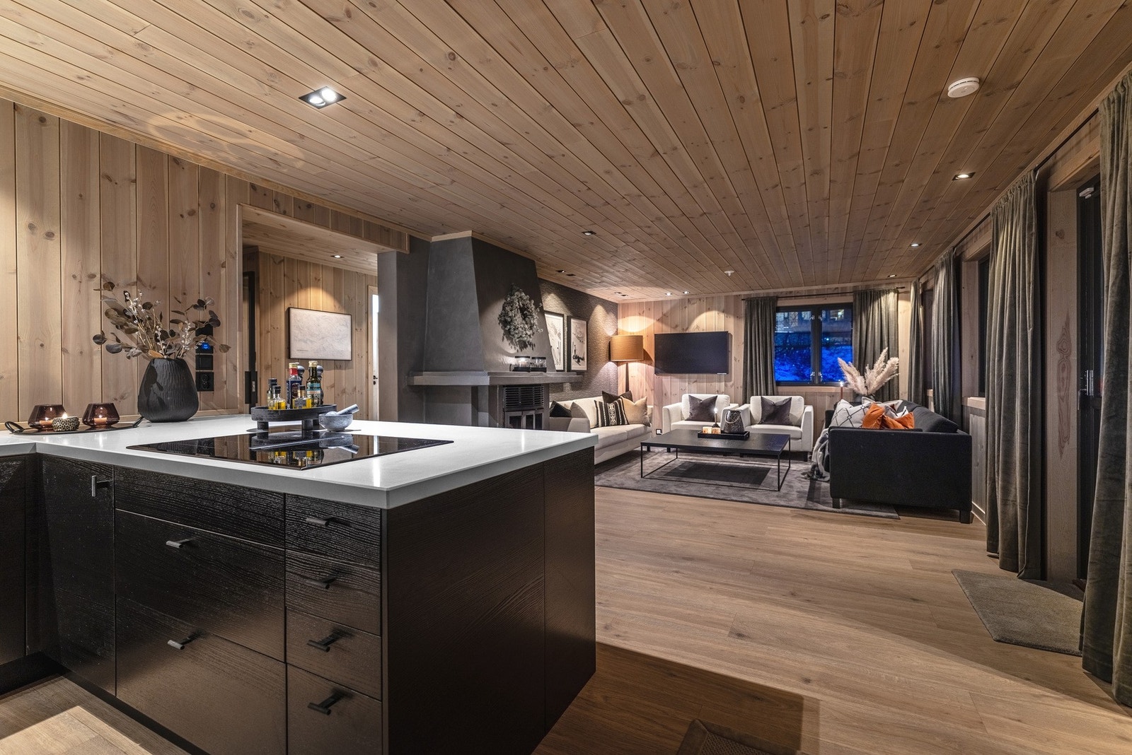 Den åpne stue- og kjøkkenløsningen er selve samlingspunktet i leiligheten, og byr på en ekte, koselig hyttefølelse med stue og kjøkken i en harmonisk flyt. Galleribilde