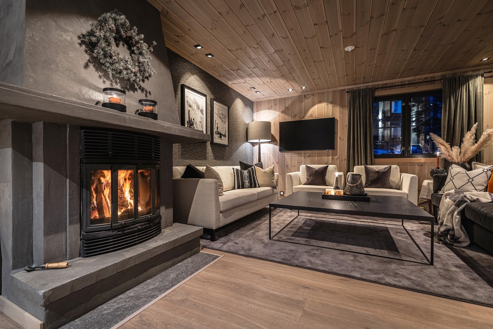 Midt i rommet står den innbydende peisen - et naturlig midtpunkt på kalde vinterdager. Den gir en deilig varme som sprer seg i hele oppholdsrommet. Galleribilde