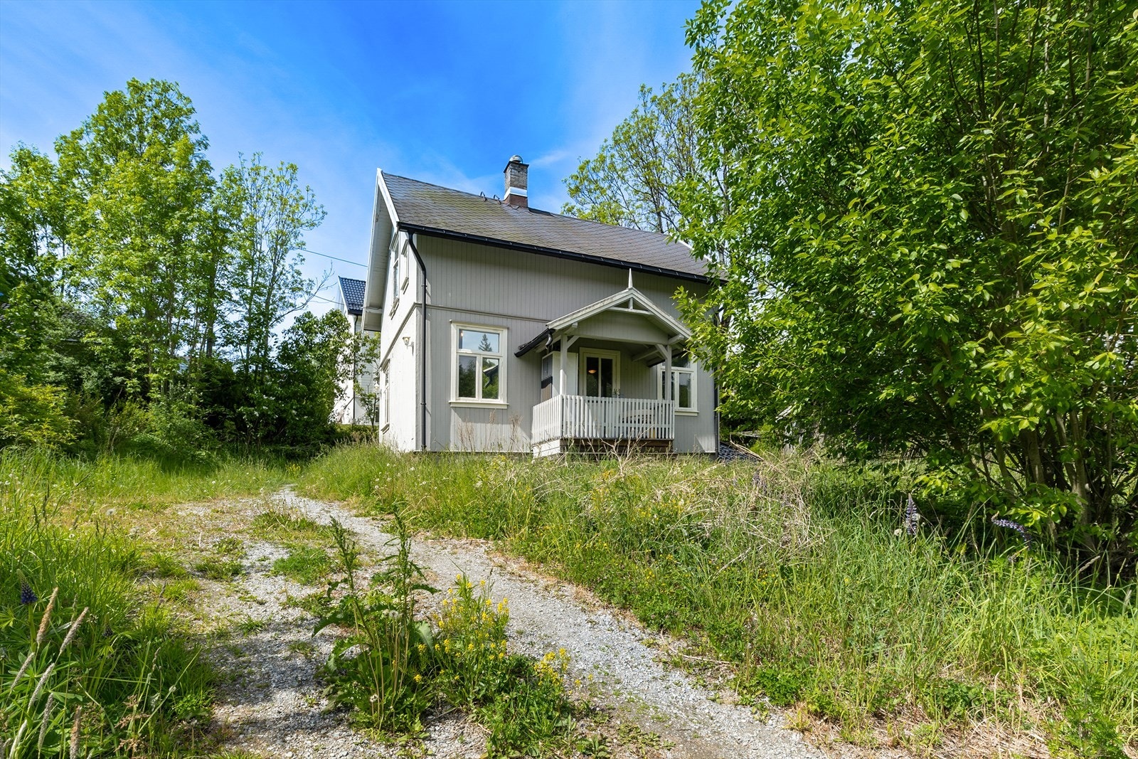 Tomten er hovedsakelig en naturtomt med gress, noe beplantning og trær. Galleribilde